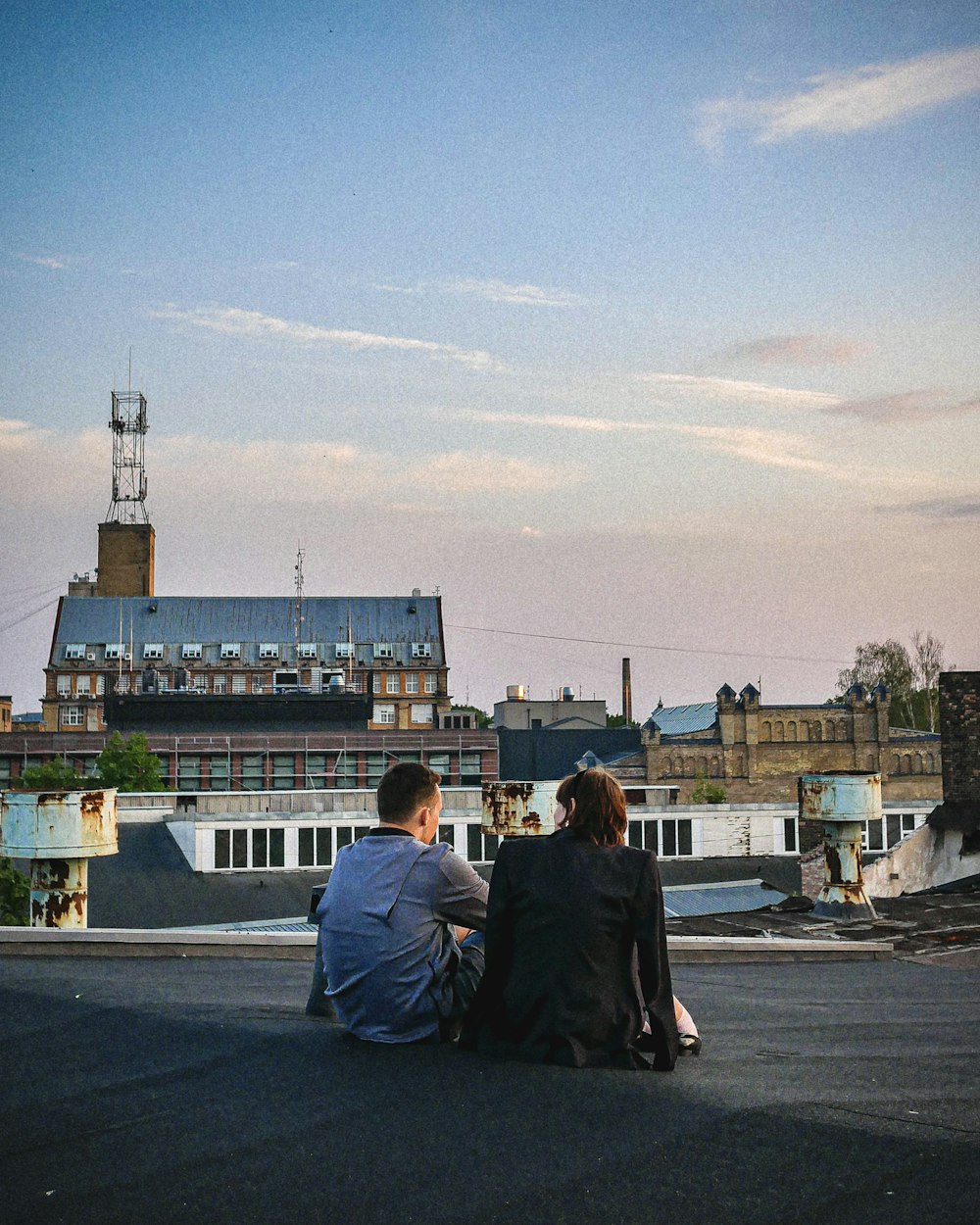 a couple of people sitting on top of a roof