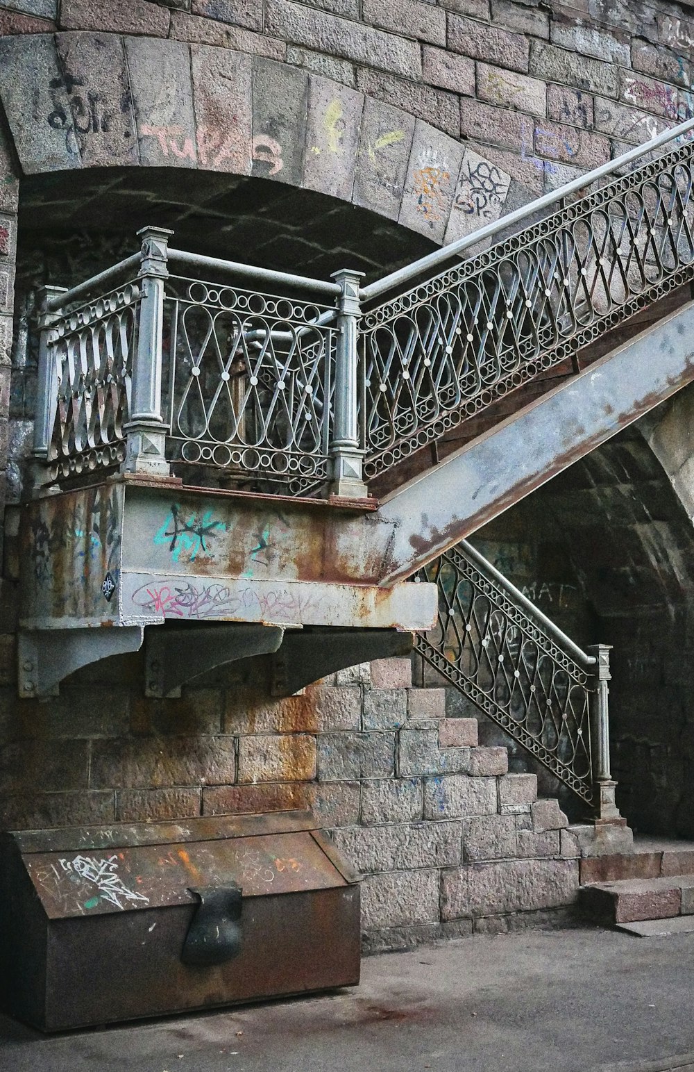 an old brick building with a staircase and graffiti on it