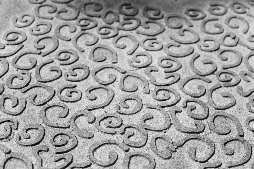 a black and white photo of a pattern on concrete