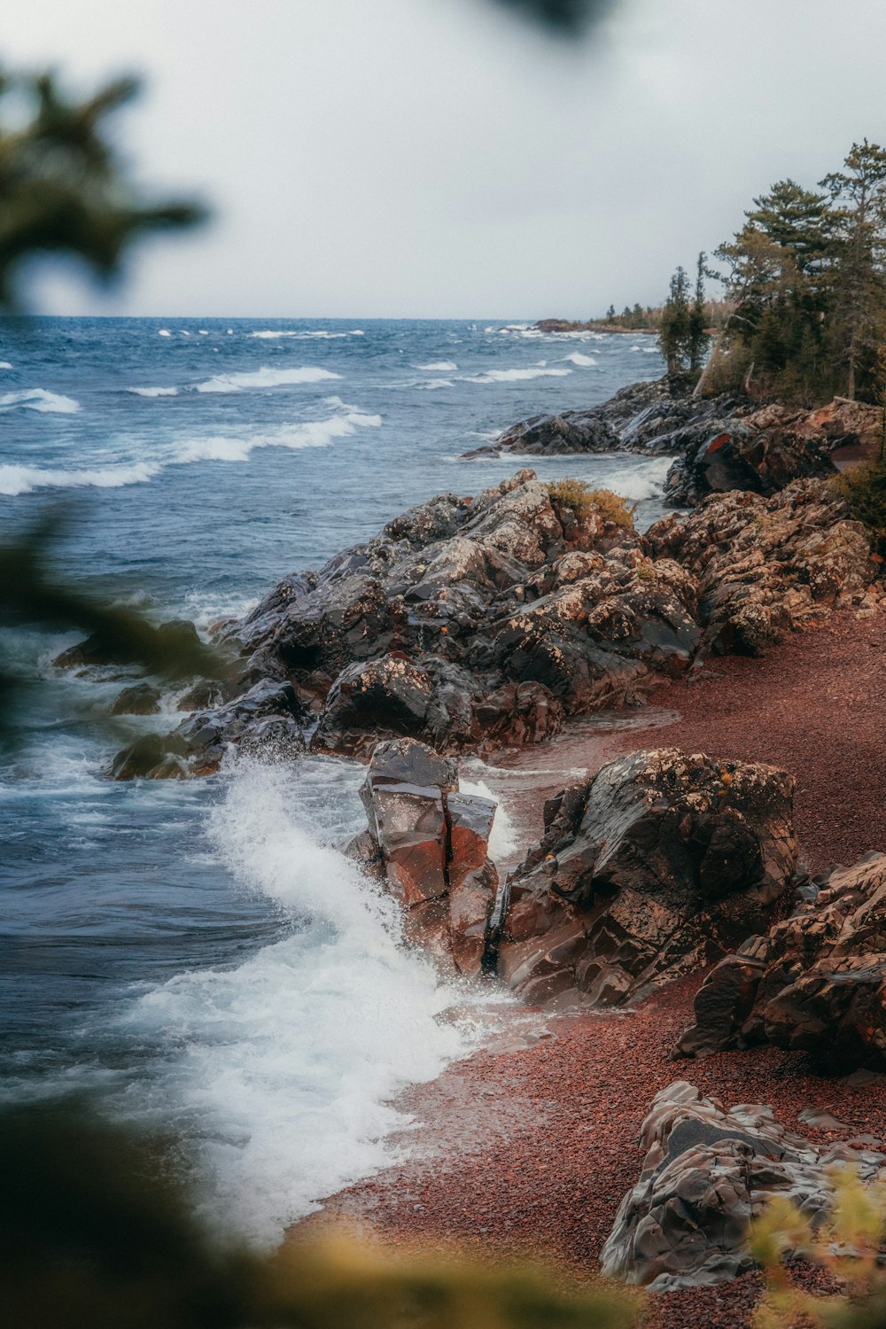 a person standing on a rocky beach next to the ocean