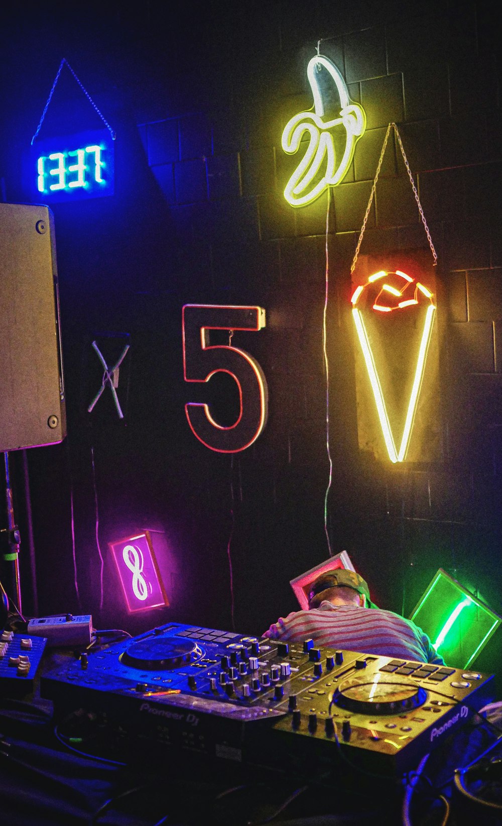 Una cabina DJ con insegne al neon e attrezzature per DJ