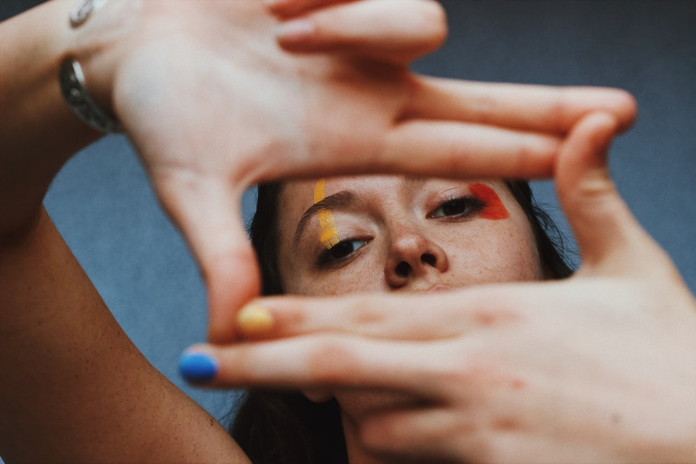 a woman holding her hands up to her face