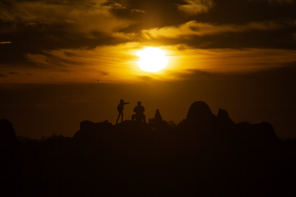 a couple of people standing on top of a hill