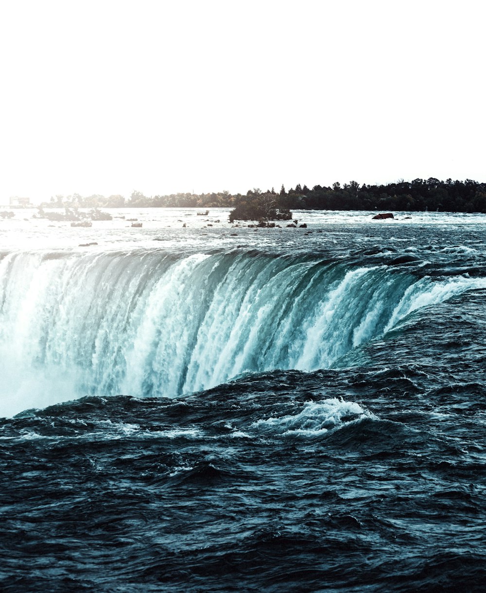 a large waterfall in the middle of a body of water