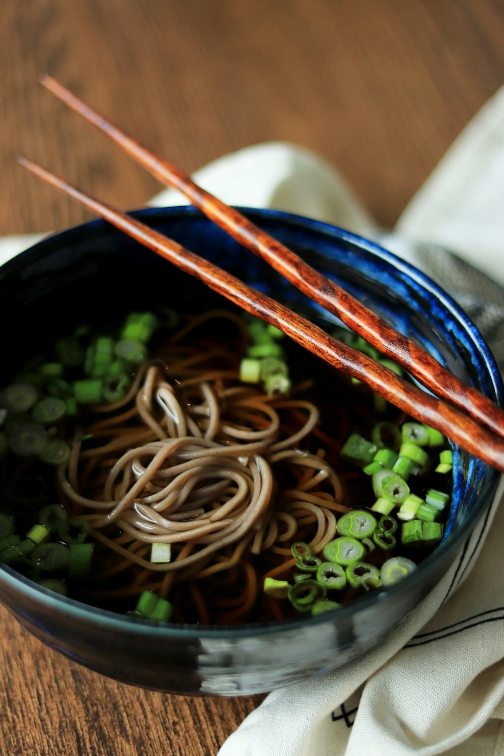 two chopsticks are sticking out of a bowl of noodles