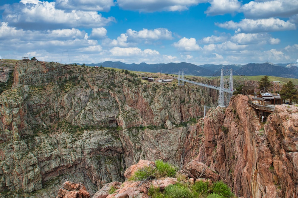 a suspension bridge over a canyon in the mountains