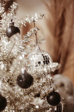 An elegant slim artificial Christmas tree adorned with delicate frosted branches and gentle twinkling lights.