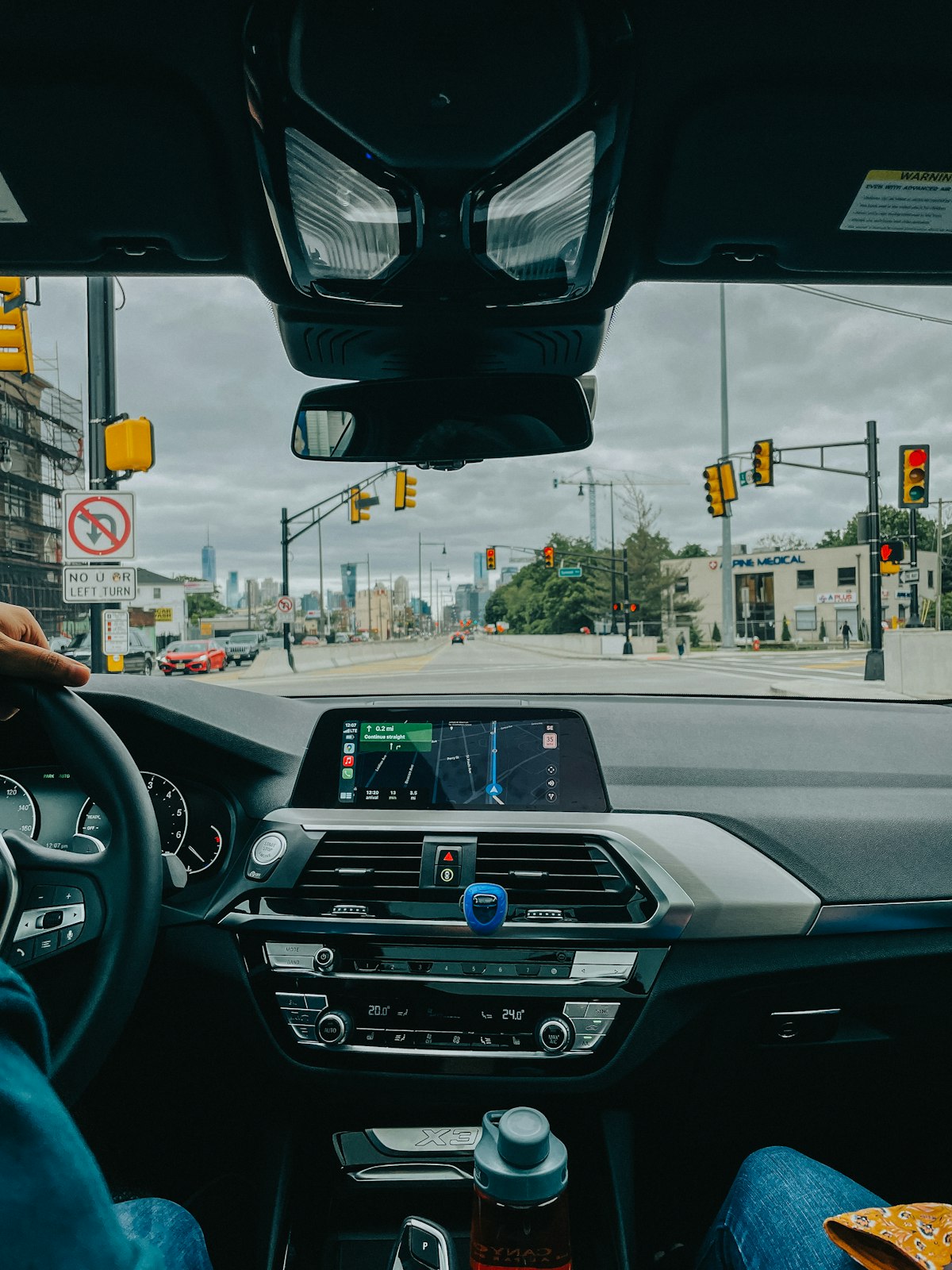 A person driving a car through city streets, viewed from inside the vehicle