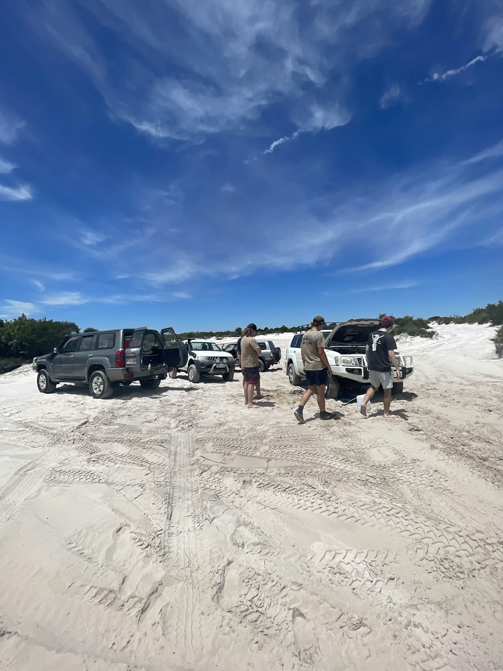 a group of people walking across a sandy beach