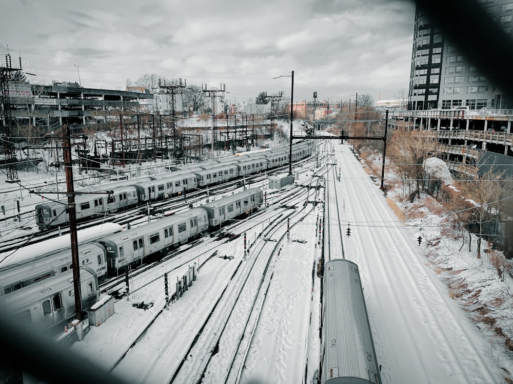 a train traveling down train tracks next to a snow covered field