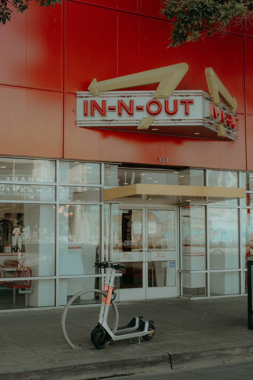 a scooter parked in front of an in - n - out restaurant