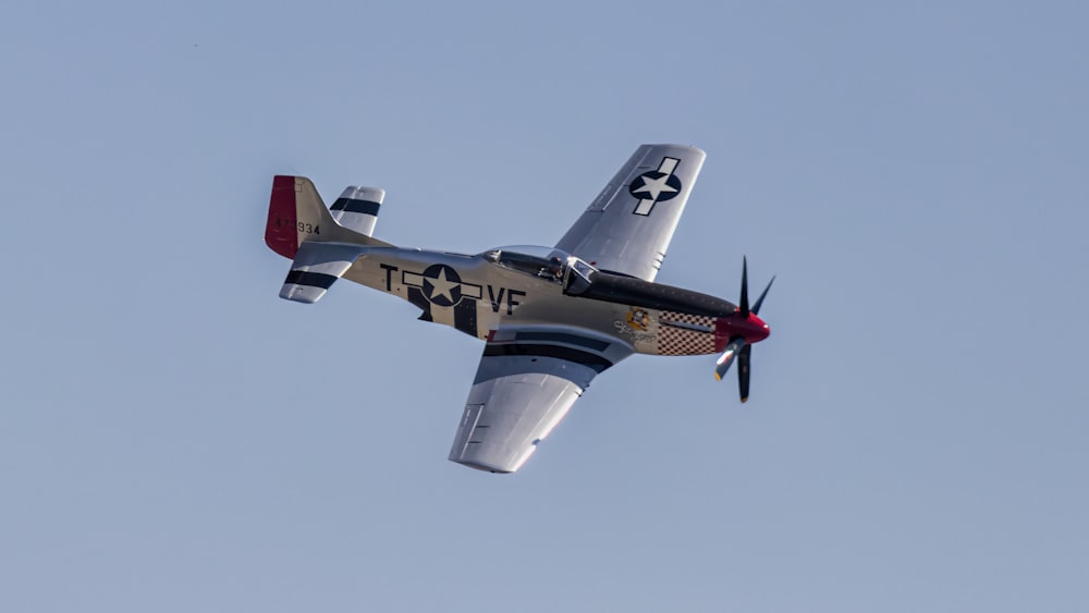 a small airplane flying through a blue sky