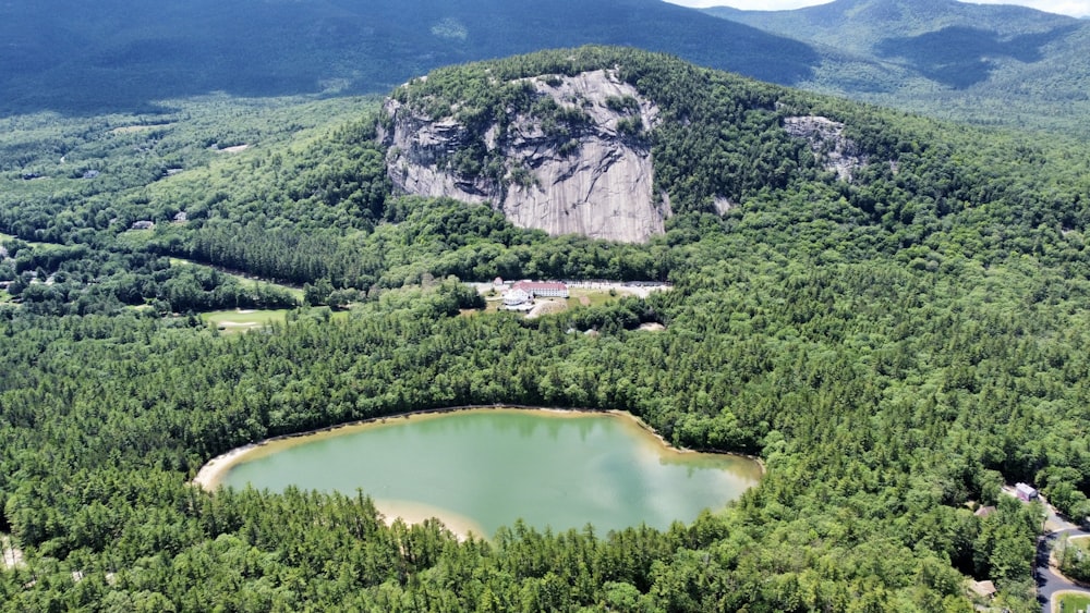 une vue aérienne d’un lac de montagne entouré d’arbres