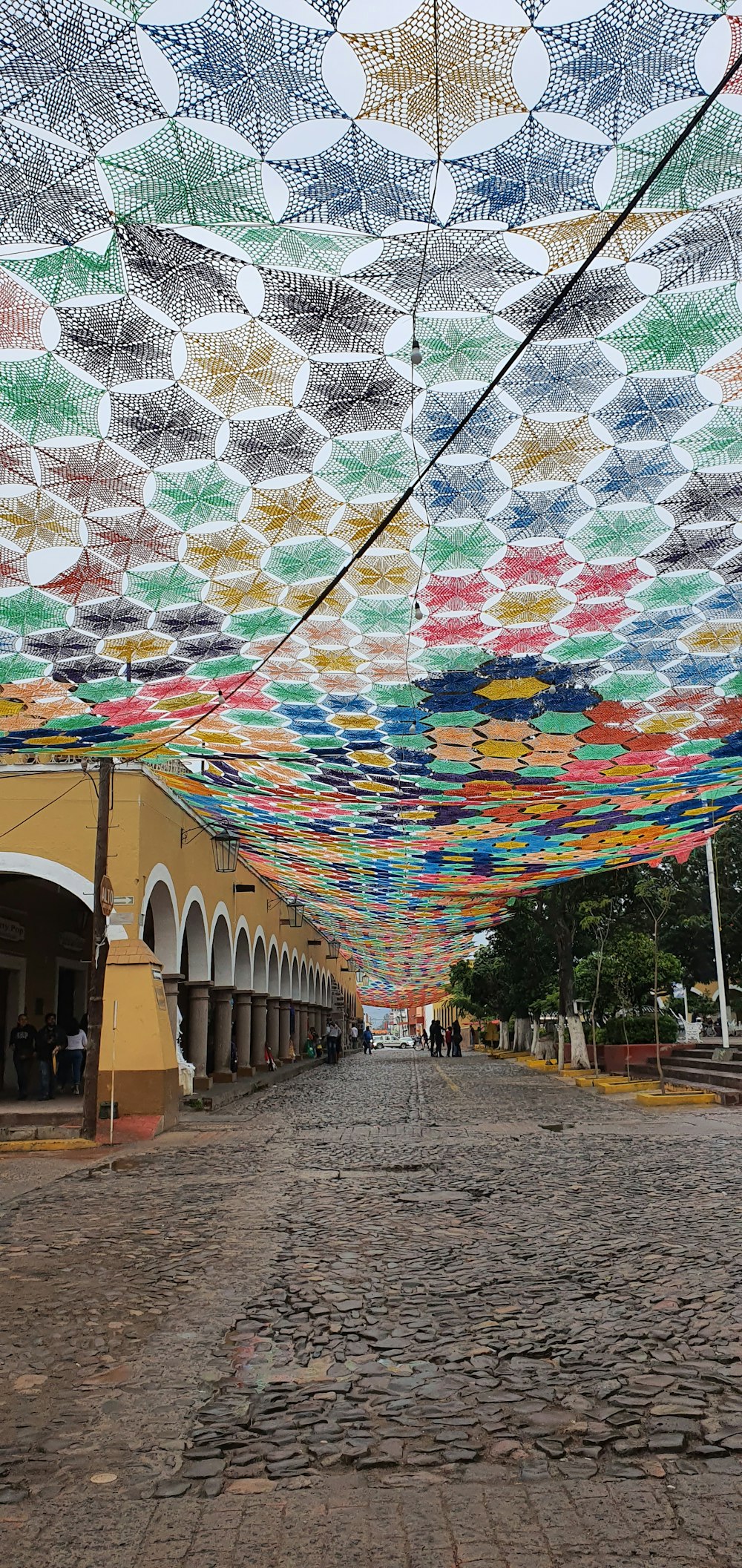 Una calle con muchos paraguas colgando del techo