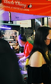 Delivery person handing over ice bags to a street food vendor in Yaowarat