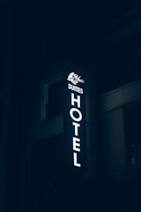 a hotel sign lit up in the dark