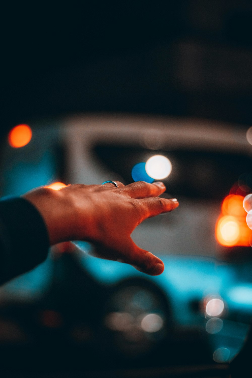 a person holding their hand out in front of a car