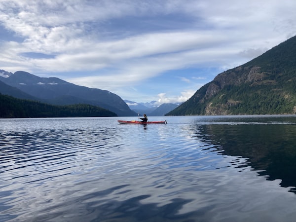 Turquoise kayak paddle on calm lake water at summer
