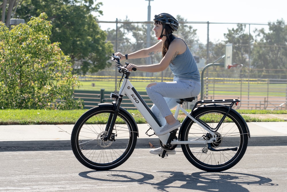 a woman riding a bike down a street