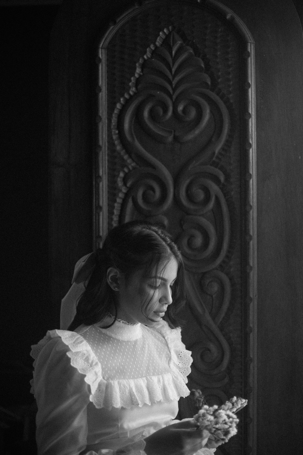 a girl in a white dress holding a bouquet of flowers