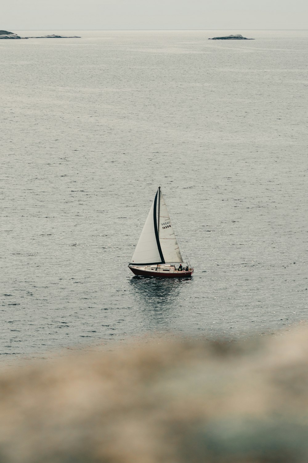 a small sailboat in the middle of a large body of water