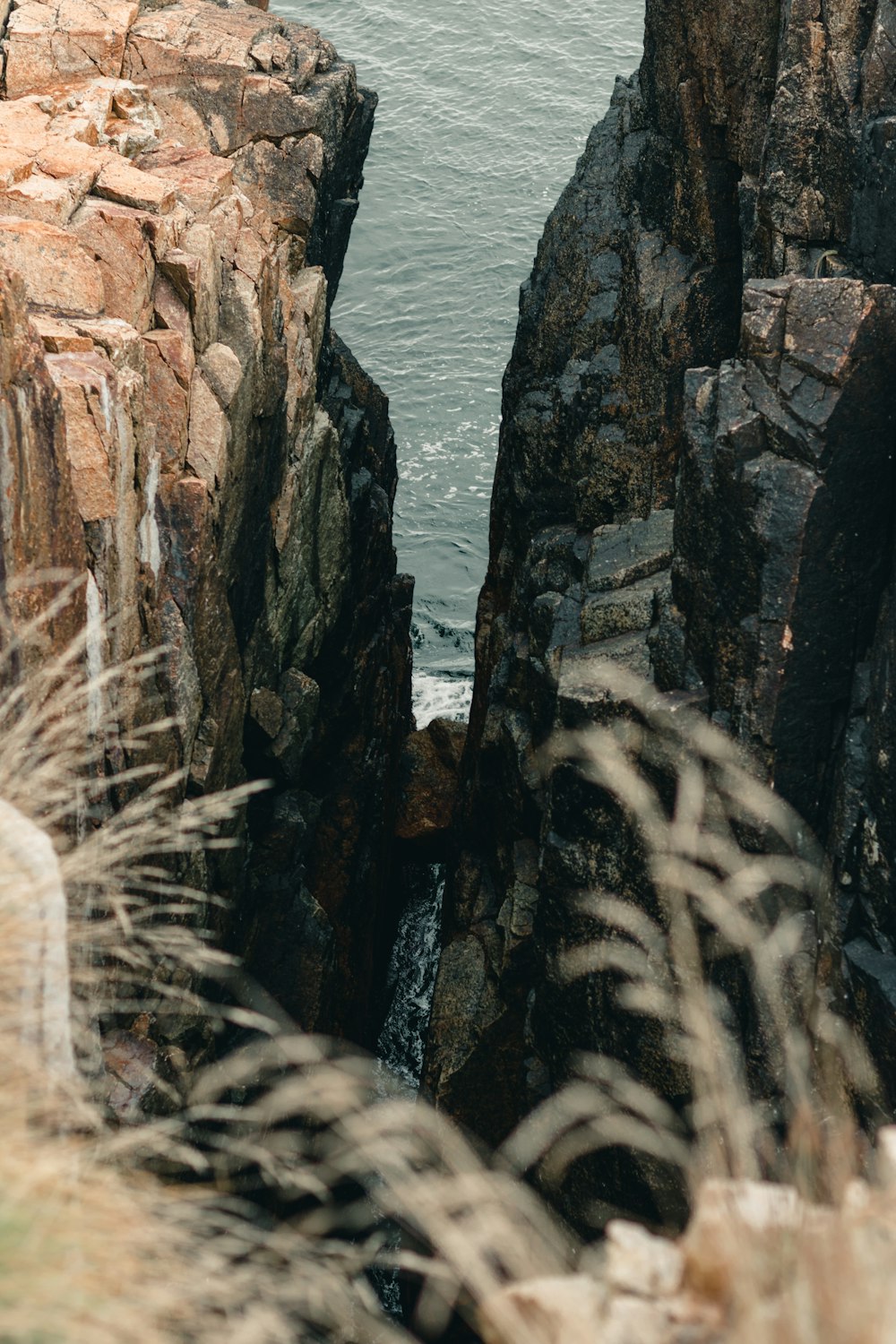 a man standing on top of a cliff next to the ocean