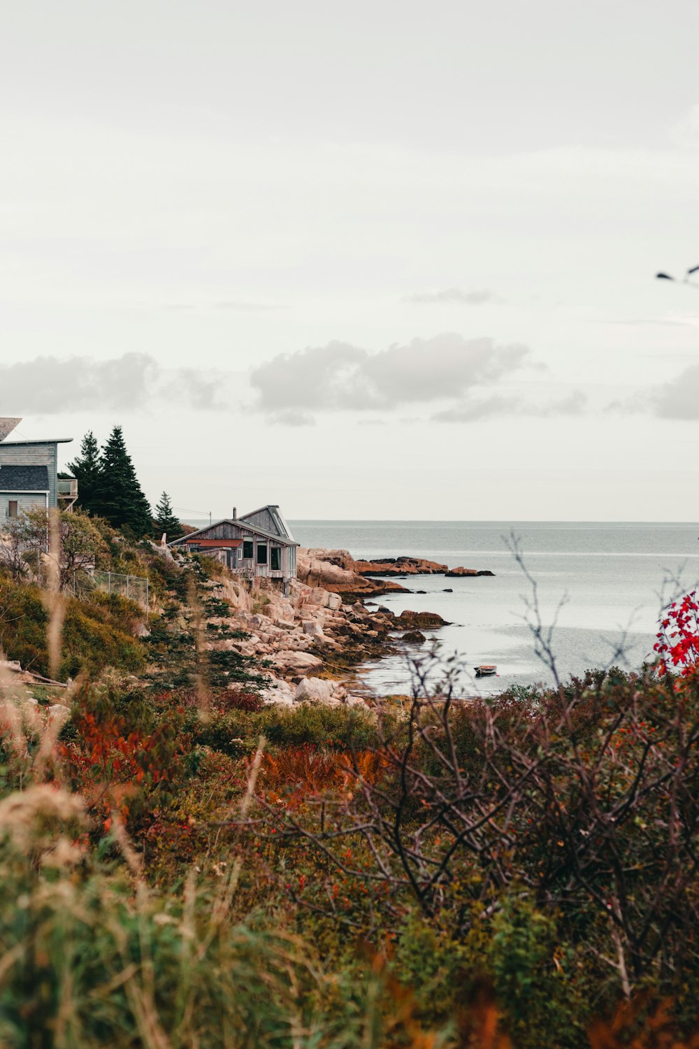 a house sitting on top of a hill next to the ocean