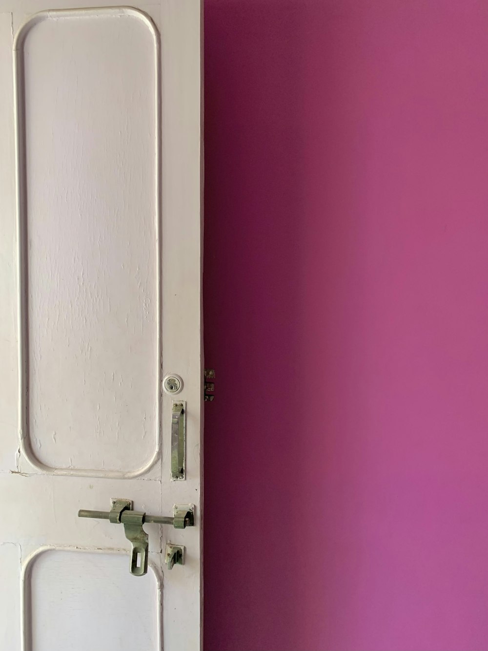 a white door with a pink wall behind it