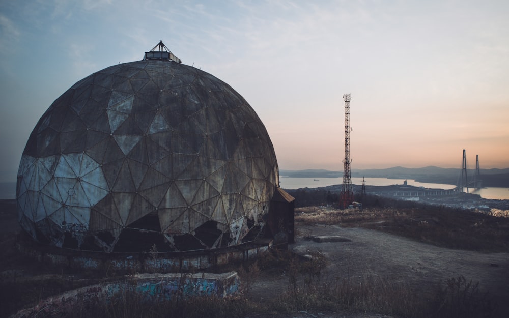 una grande cupola di metallo seduta in cima a un campo sporco
