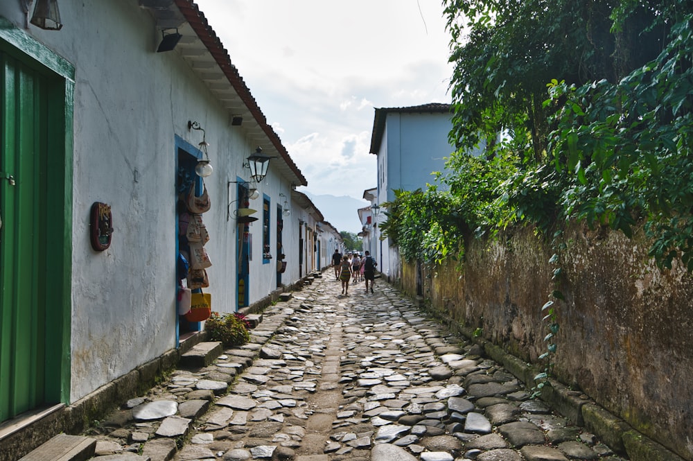 a cobblestone street with people walking down it