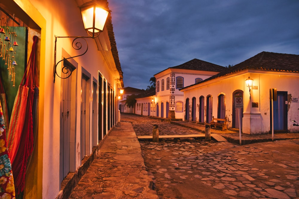 a cobblestone street lined with white buildings