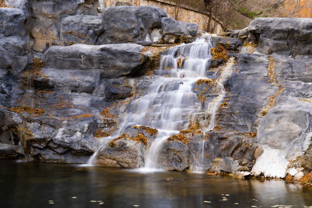 a waterfall is shown in the middle of a pond