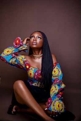 A model posing in a trendy ethnic top paired with modern accessories against a minimal backdrop.