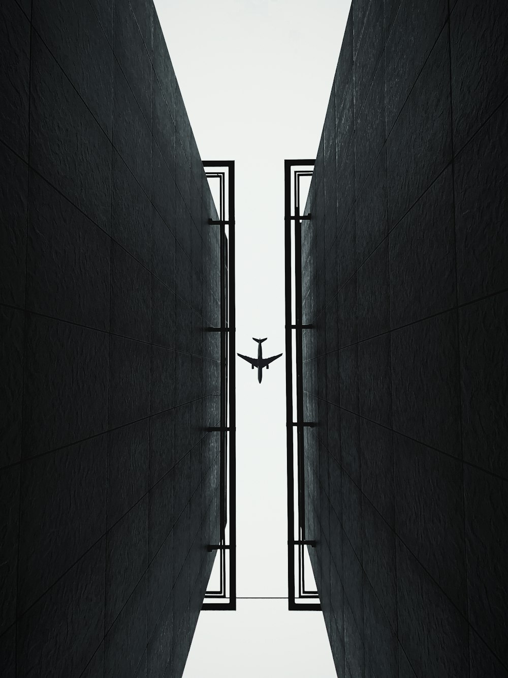 an airplane is flying through the air between two buildings
