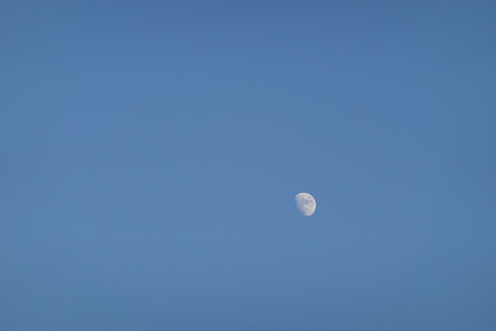 Un avión volando en el cielo con la luna al fondo