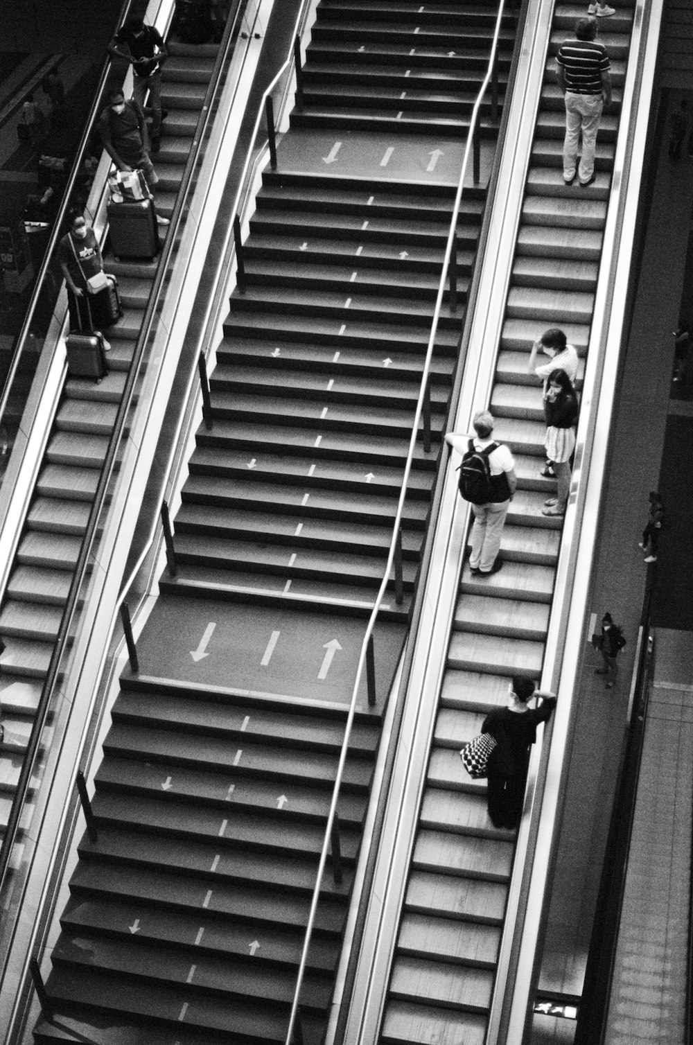 a couple of people riding down an escalator