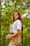 a young woman standing in the woods holding a cell phone