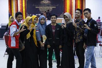 A diverse group of young athletes, boys and girls, standing together proudly on a competition stage.