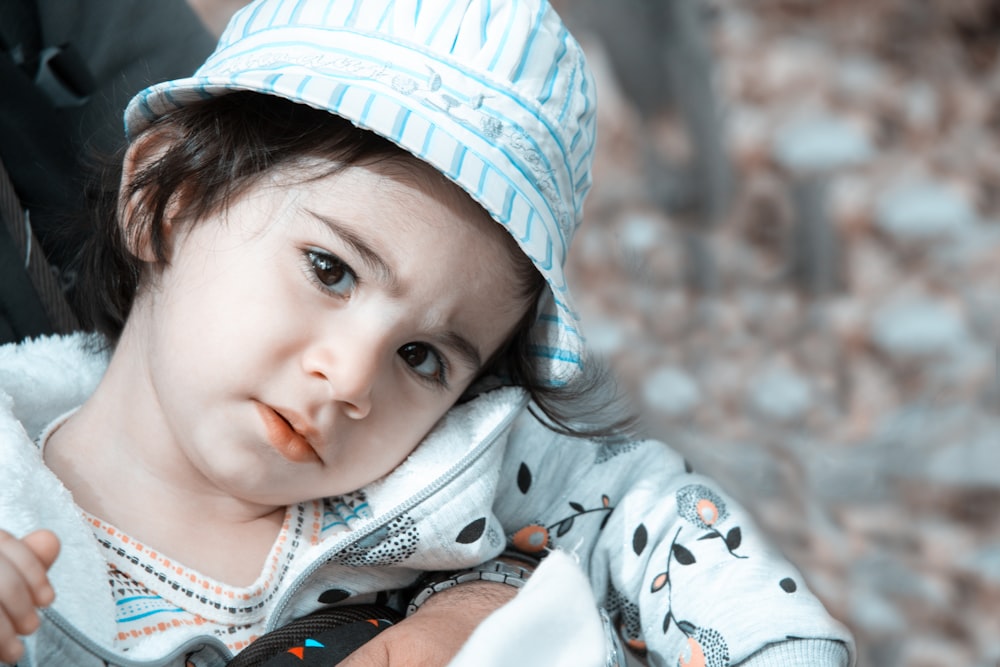 Un niño pequeño con un sombrero azul y blanco