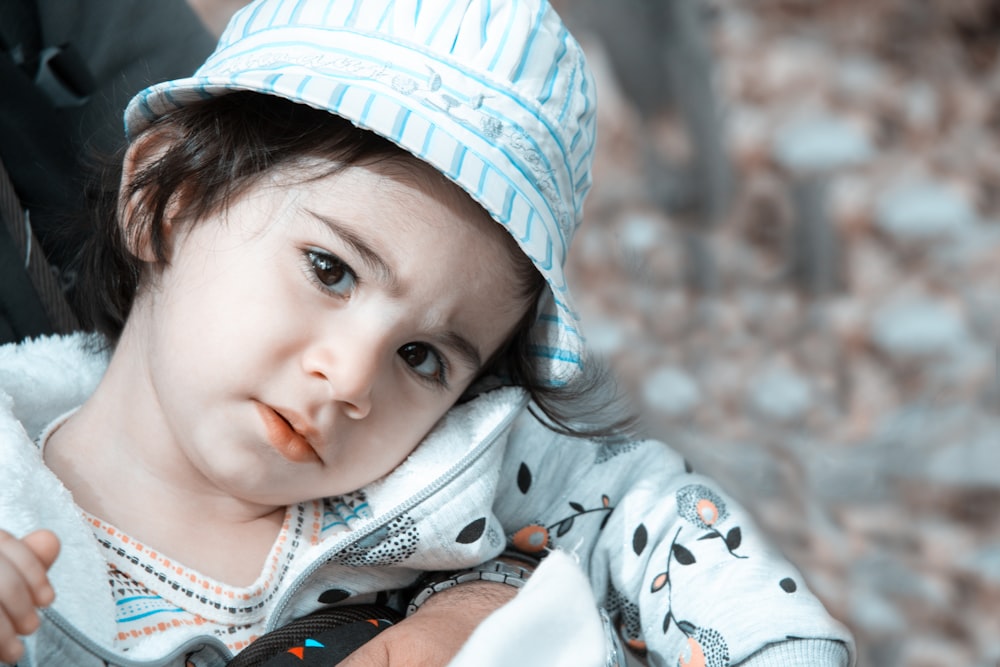 a small child wearing a blue and white hat