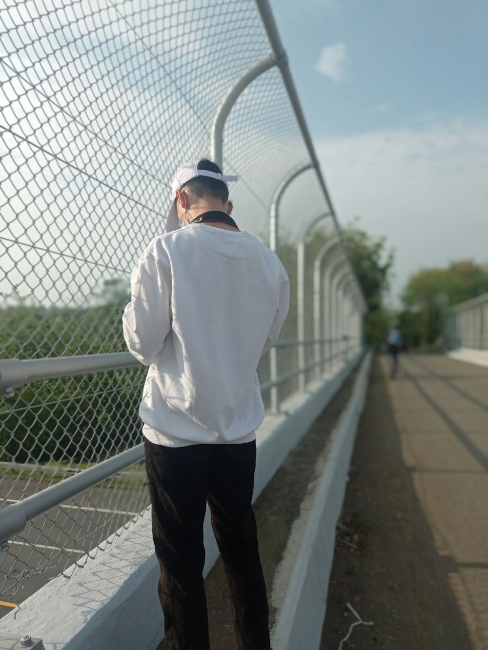 a man standing on a bridge with his back to the camera