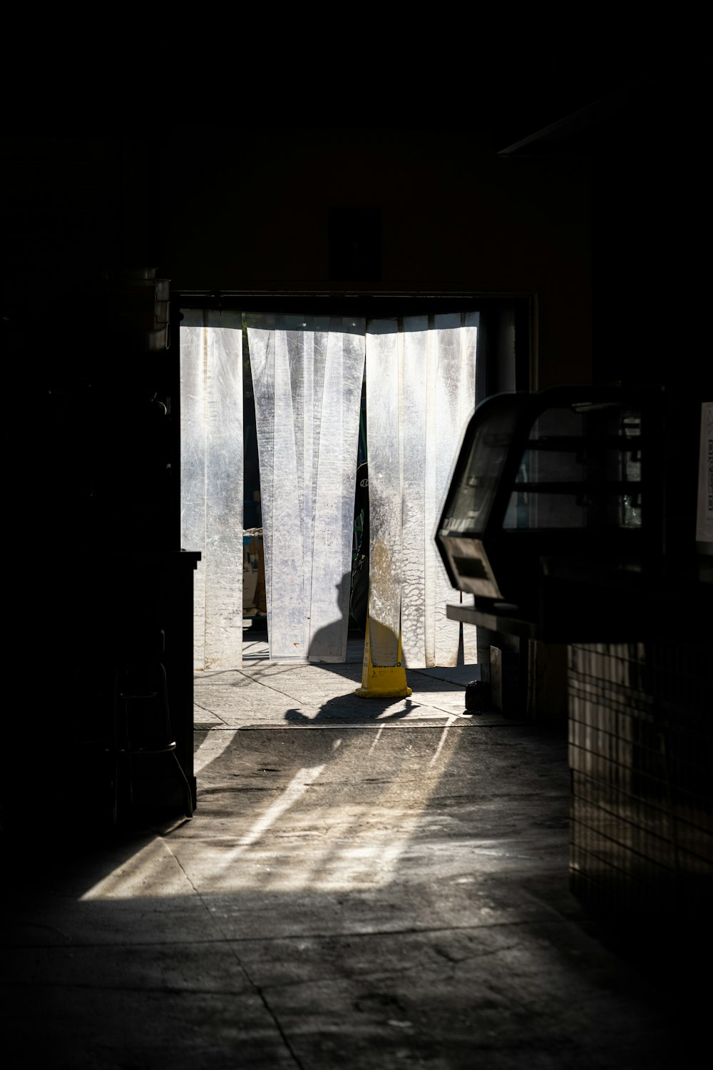 a dark room with a piano and curtains