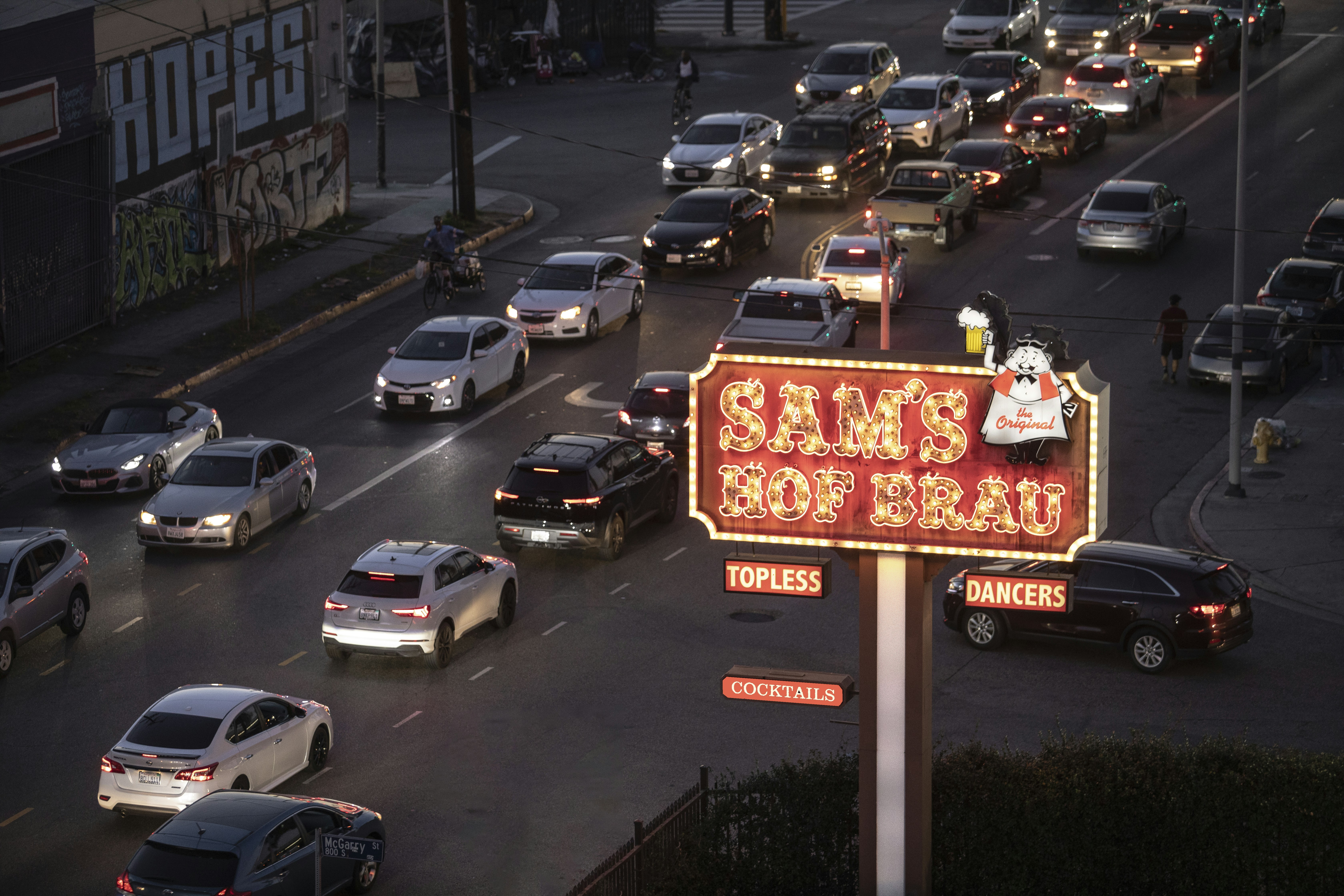 a street filled with lots of traffic next to tall buildings