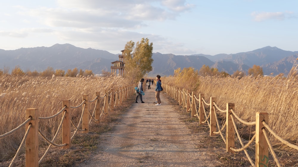 a group of people walking down a dirt road