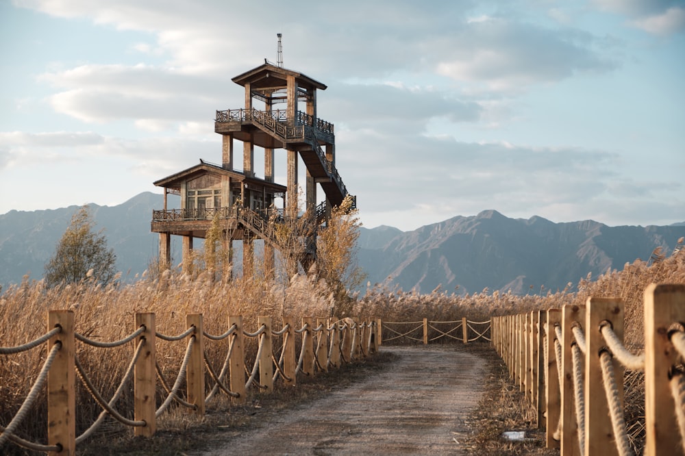 a tall wooden tower sitting on the side of a dirt road