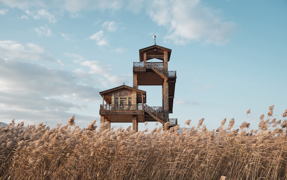 a tall tower sitting on top of a dry grass field