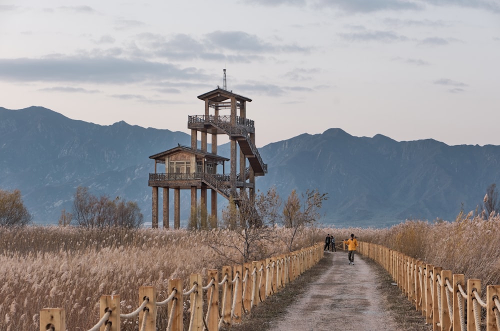 a tall tower sitting on the side of a dirt road