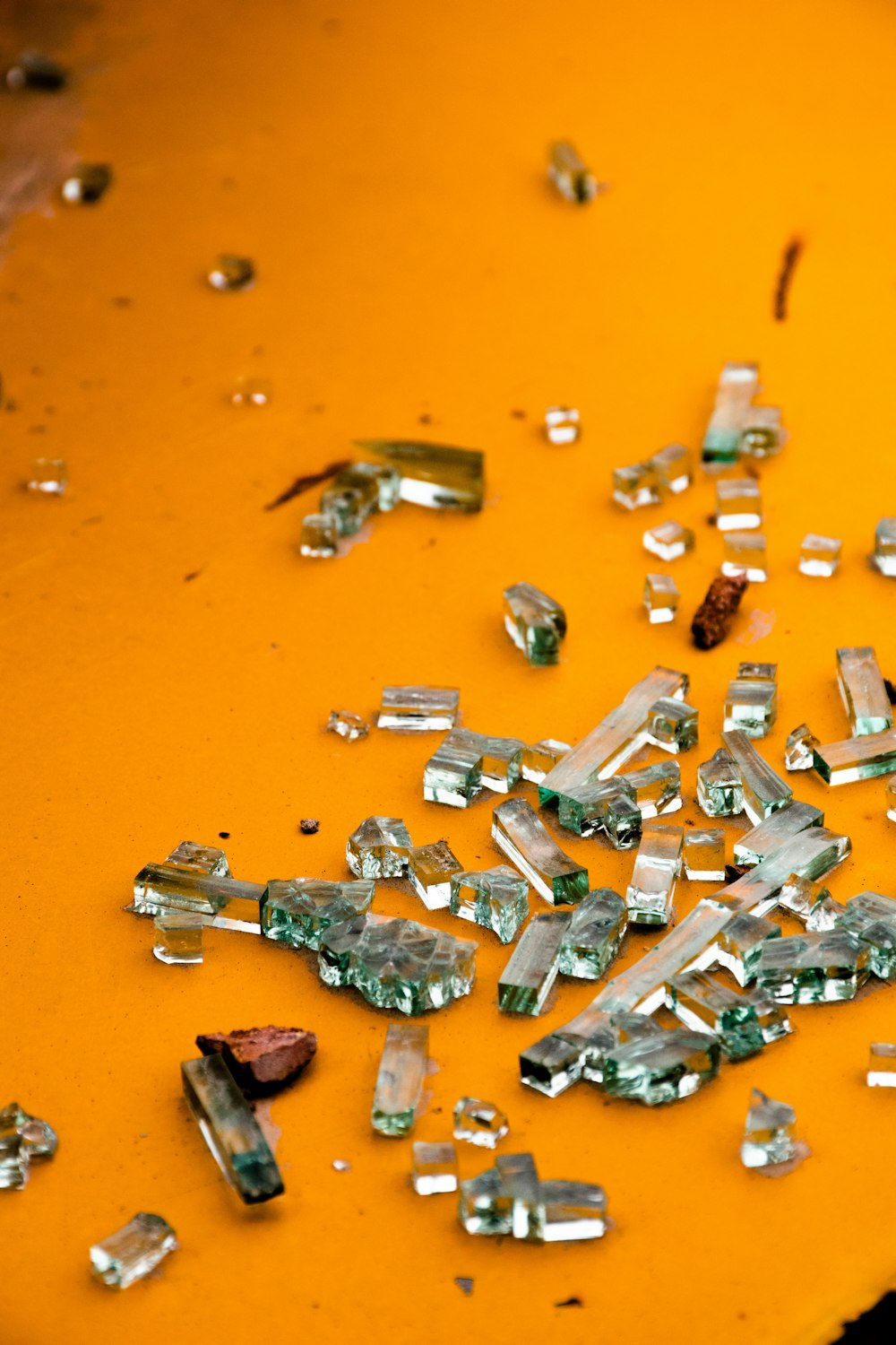 a bunch of broken glass sitting on top of a yellow table