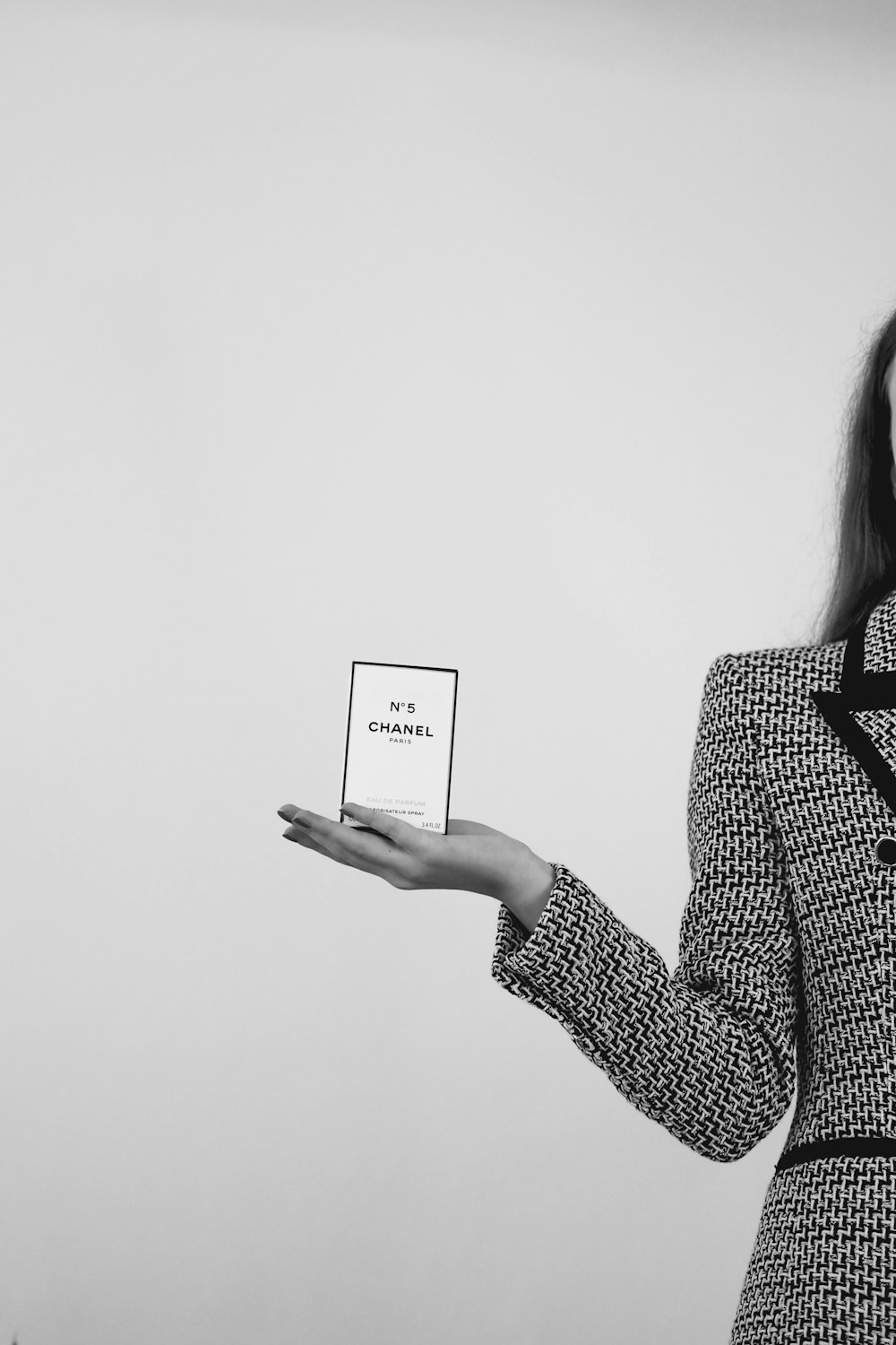 a woman in a suit holding a small box