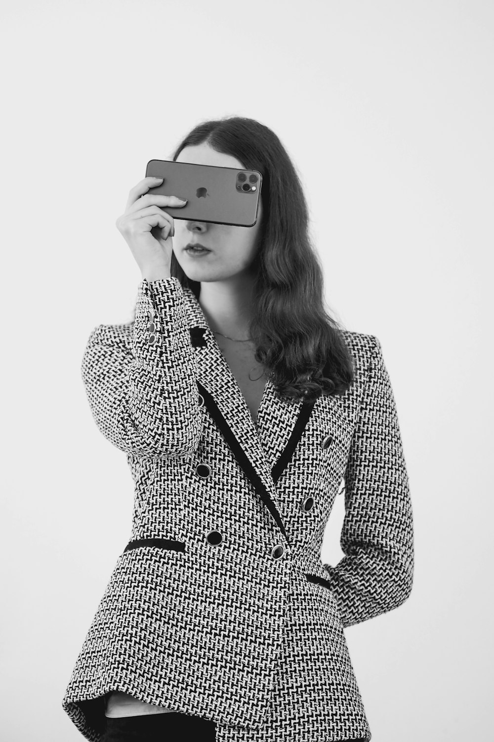 a woman in a suit holding a cell phone up to her face